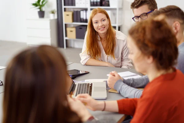 Joyeux roux jeune femme aux cheveux avec des collègues — Photo