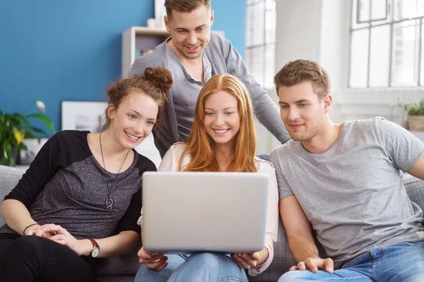 Group of good looking friends seated on couch — Stock Photo, Image