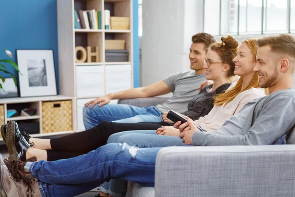 Grupo de amigos relaxantes assistindo televisão — Fotografia de Stock