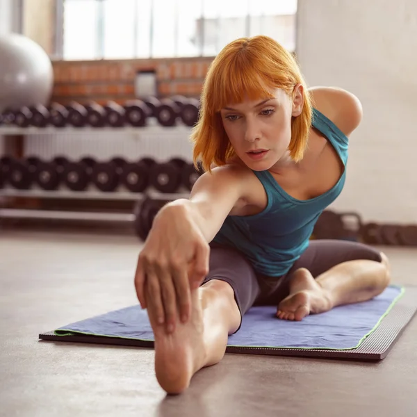 Jovem mulher flexível trabalhando em um ginásio — Fotografia de Stock