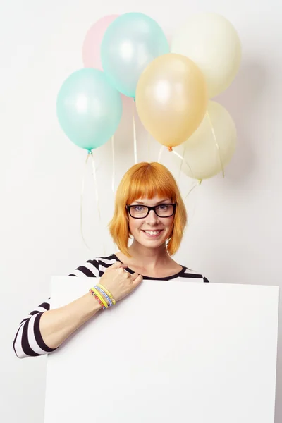 Smiling woman with party balloons and a sign — Stock Photo, Image