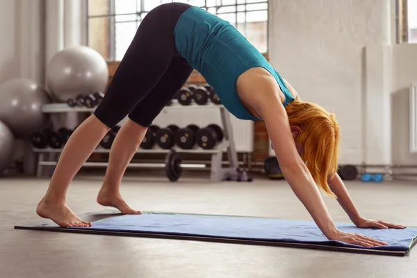 Mujer tonificada flexible haciendo ejercicio en un gimnasio —  Fotos de Stock