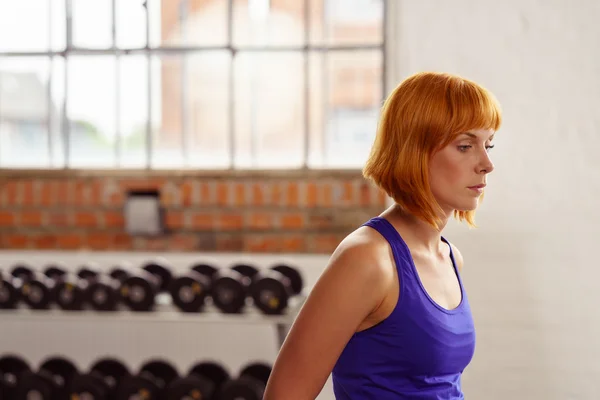 Mujer joven seria caminando a través de un gimnasio — Foto de Stock