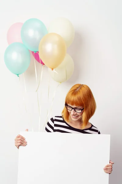 Mujer joven sosteniendo un cartel y globos de fiesta —  Fotos de Stock