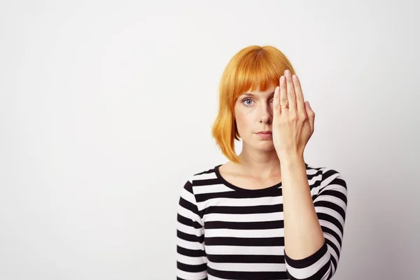 Young redhead woman covering one eye — 图库照片