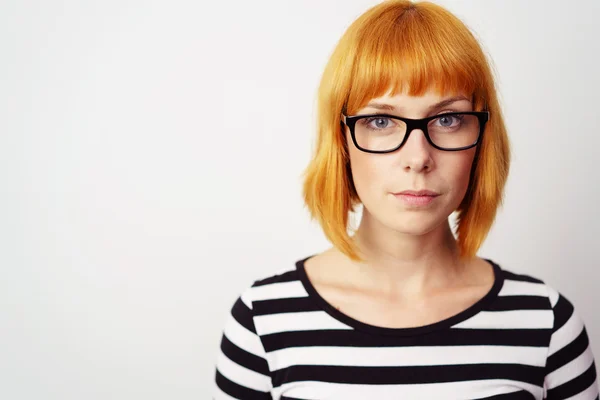 Allvar ung rödhårig kvinna bär glasögon — Stockfoto