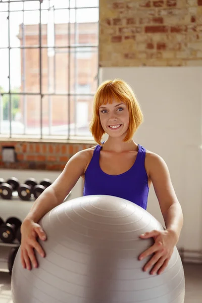 Amichevole giovane donna che tiene un pilates o una palla da palestra — Foto Stock