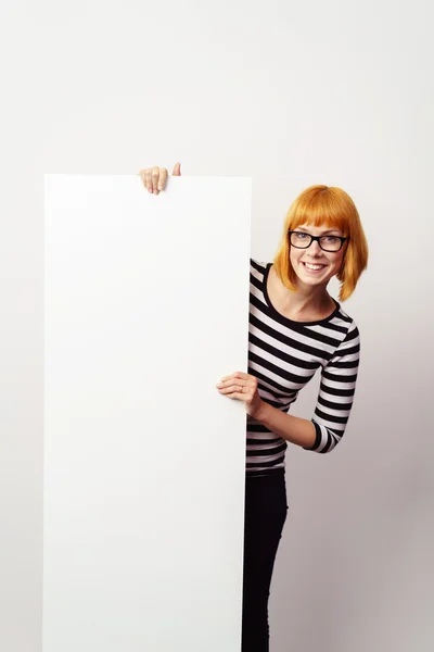 Mujer amigable sosteniendo un signo vertical en blanco — Foto de Stock