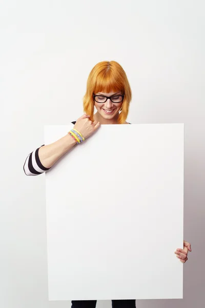 Gelukkige aantrekkelijke vrouw die een blanco teken vasthoudt — Stockfoto