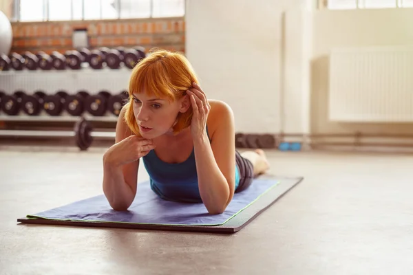 Nachdenkliche ernsthafte Frau, die in einem Fitnessstudio trainiert — Stockfoto