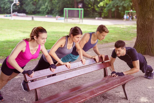 Vier gesunde, fitte Menschen, die im Park trainieren — Stockfoto