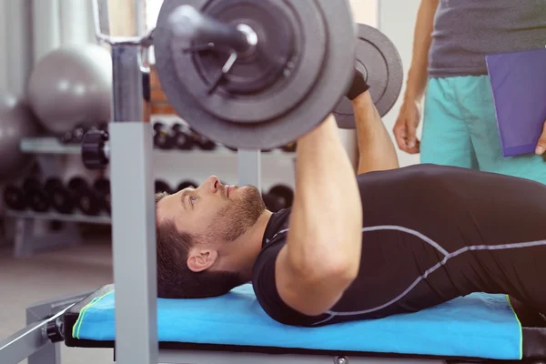 Barbell bench press itişle üzerinde çalışan adam — Stok fotoğraf