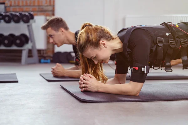 Жінка вправи в спортзалі на йога килимок, крім чоловіка — стокове фото