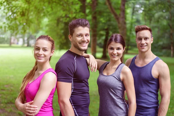 Smiling athletes stand together in forest clearing — Stock Photo, Image