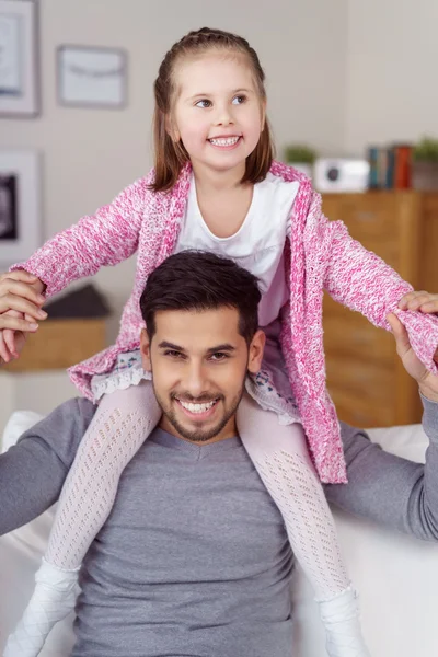 Szczęśliwa mała dziewczynka siedzi na ramionach ojców — Zdjęcie stockowe
