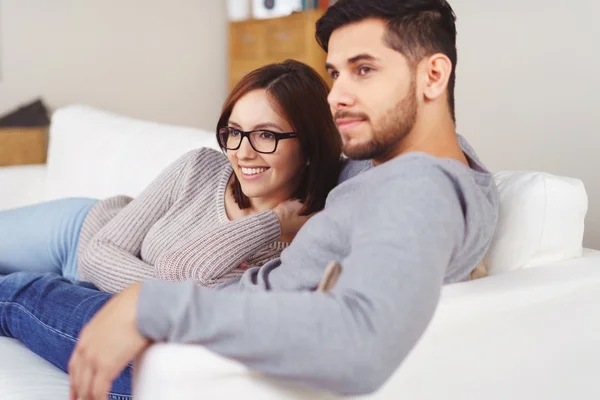 Mann auf Sofa mit Freundin schaut sich etwas an — Stockfoto