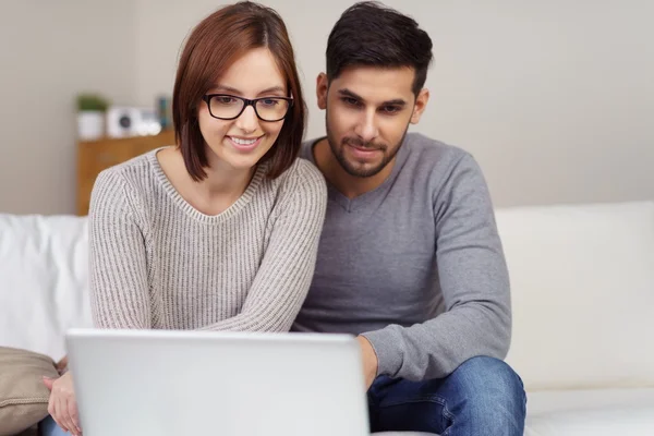 Casal afetuoso compartilhando um computador portátil — Fotografia de Stock