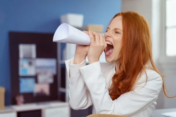 Young businesswoman using a paper megaphone — Stockfoto