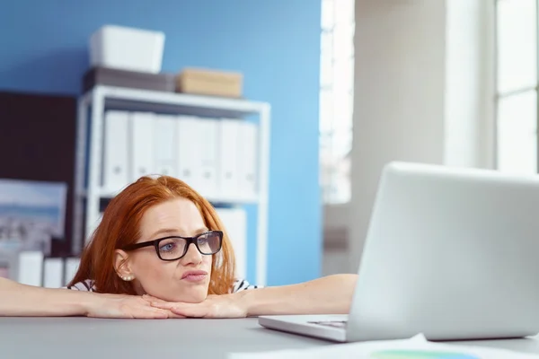 Bored worker at desk behind laptop computer — Stock Photo, Image