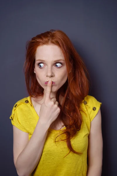 Thoughtful young woman with her finger to her lip — Stock Photo, Image