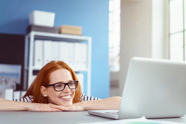 Lachende Frau blickt auf Laptop-Computer — Stockfoto