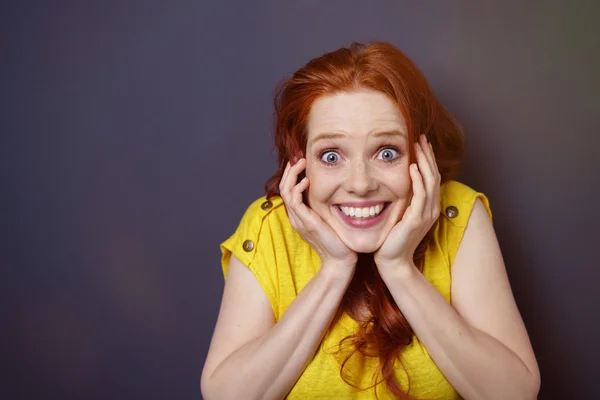 Excited woman holding her own head — Stock Photo, Image