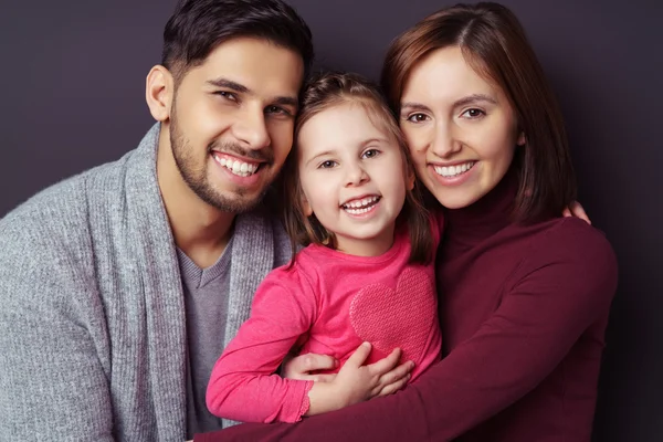 Gelukkig glimlachend klein meisje met haar ouders — Stockfoto