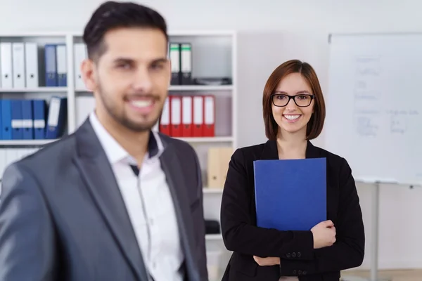 Geschäftsfrau hinter Mann im Büro — Stockfoto