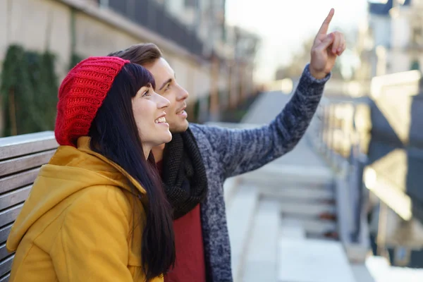 Young couple pointing up at an urban building — Stock Photo, Image