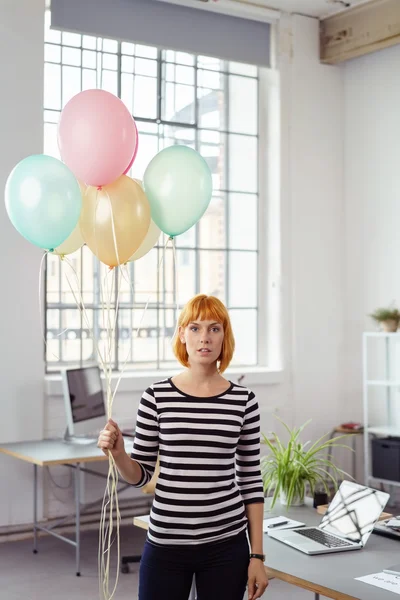 Relaxed informal businesswoman holding balloons — Stock Photo, Image