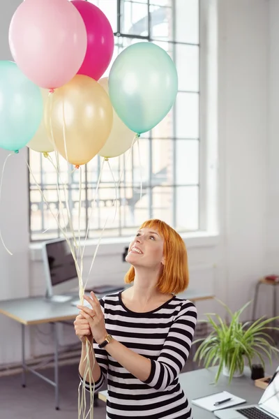 Happy young woman celebrating in the office — ストック写真