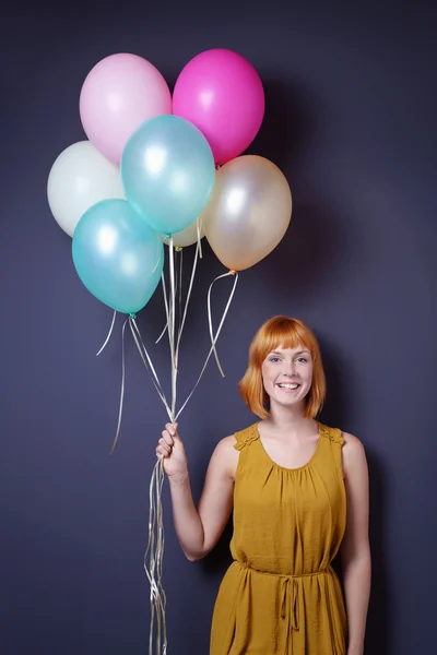 Happy proud young woman holding party balloons — Stock Photo, Image