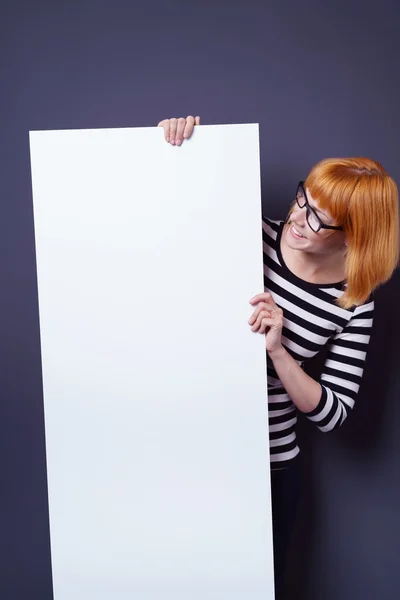 Happy young woman reading a blank white sign — Stock Photo, Image