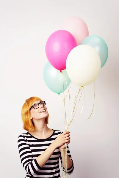 Giovane donna con un mucchio di palloncini galleggianti — Foto Stock