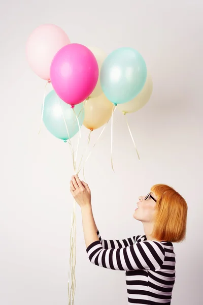 Zijaanzicht van een jonge vrouw met ballonnen — Stockfoto