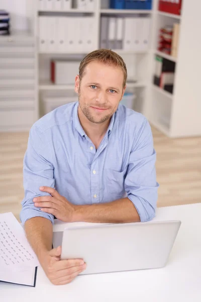 Homme d'affaires amical assis à son bureau — Photo