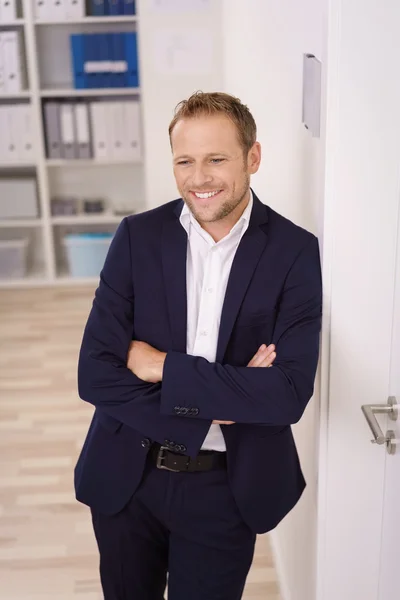 Young man standing with folded arms in the office — Stock Fotó