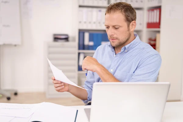 Sérieux jeune homme d'affaires étudiant un document — Photo