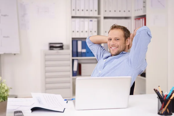 Vriendelijke zakenman ontspannen op kantoor — Stockfoto
