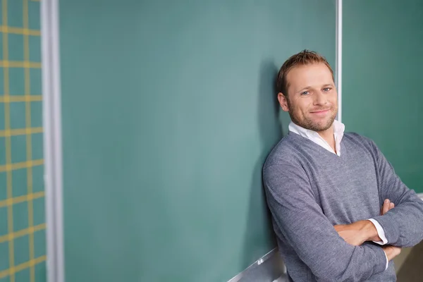 Gelukkig ontspannen mannelijke leraar in een klaslokaal — Stockfoto