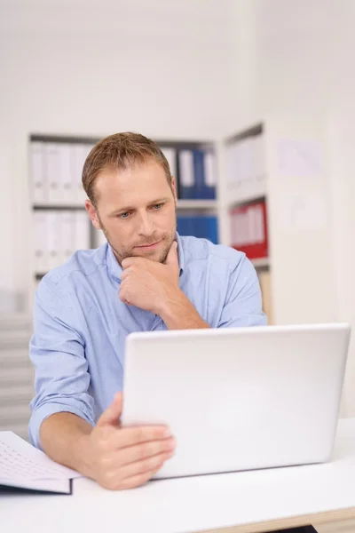 Hardwerkende zakenman leest zijn laptop — Stockfoto