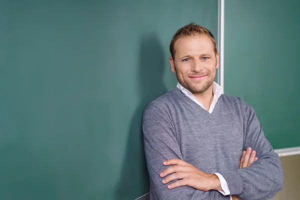 Lächelnder selbstbewusster männlicher Lehrer mit verschränkten Armen — Stockfoto