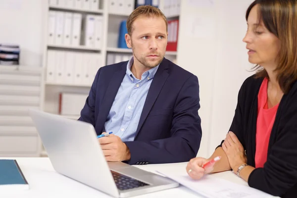 Orolig affärsman lyssnande till en kollega — Stockfoto