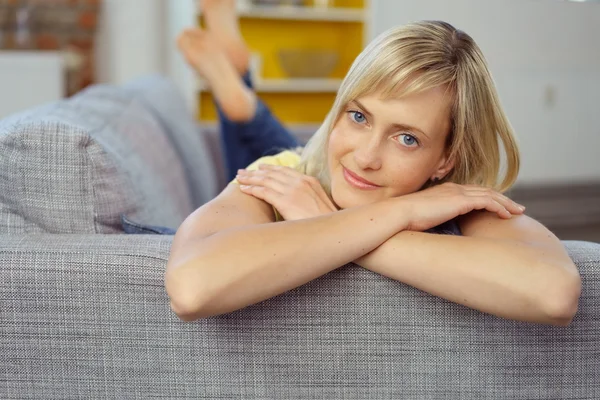 Женщина лежит на диване со сложенными руками — стоковое фото