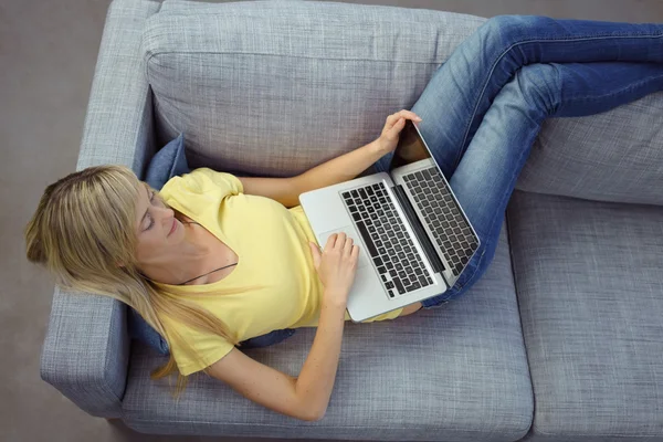 Mujer de camisa amarilla con ordenador portátil abierto — Foto de Stock