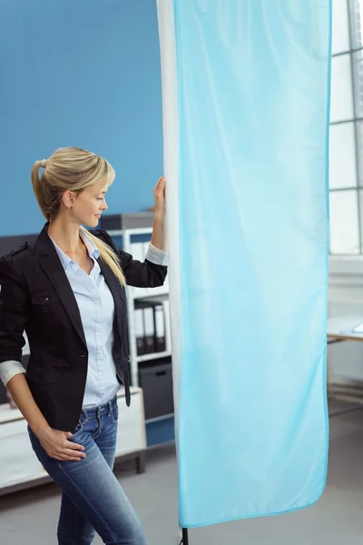 Woman standing beside blank banner with copy space — Stockfoto