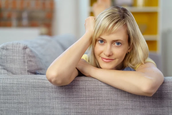 Woman relaxing on sofa with folded arms — Stok fotoğraf