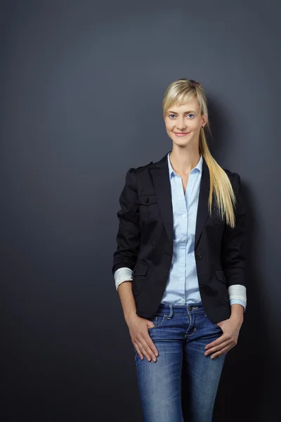 Slim young woman in front of wall with copy space — Stock Photo, Image