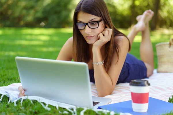 Woman working outside with her laptop — Stockfoto