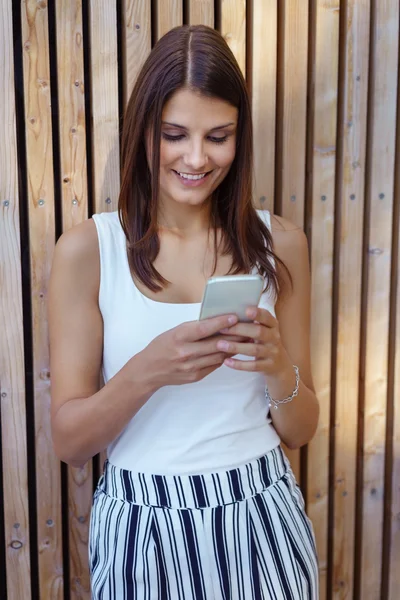 Woman with happy expression using phone — Stock fotografie